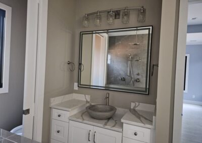 Bathroom Quartz countertop. The bathroom has a vessel sink and 4 inch backsplash along the wall.
