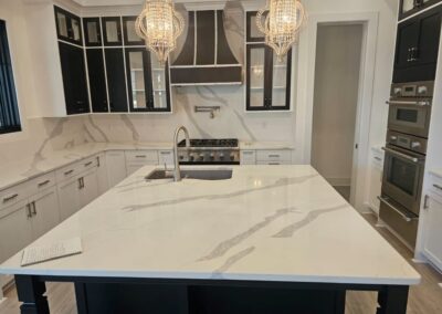 Close up of the island in a kitchen. The stone is quartz with a few large veins running through it.